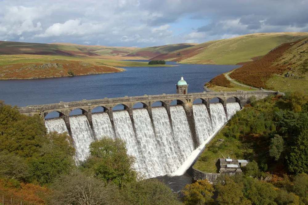 summer road trip | mountain dam with waterfall over edge 