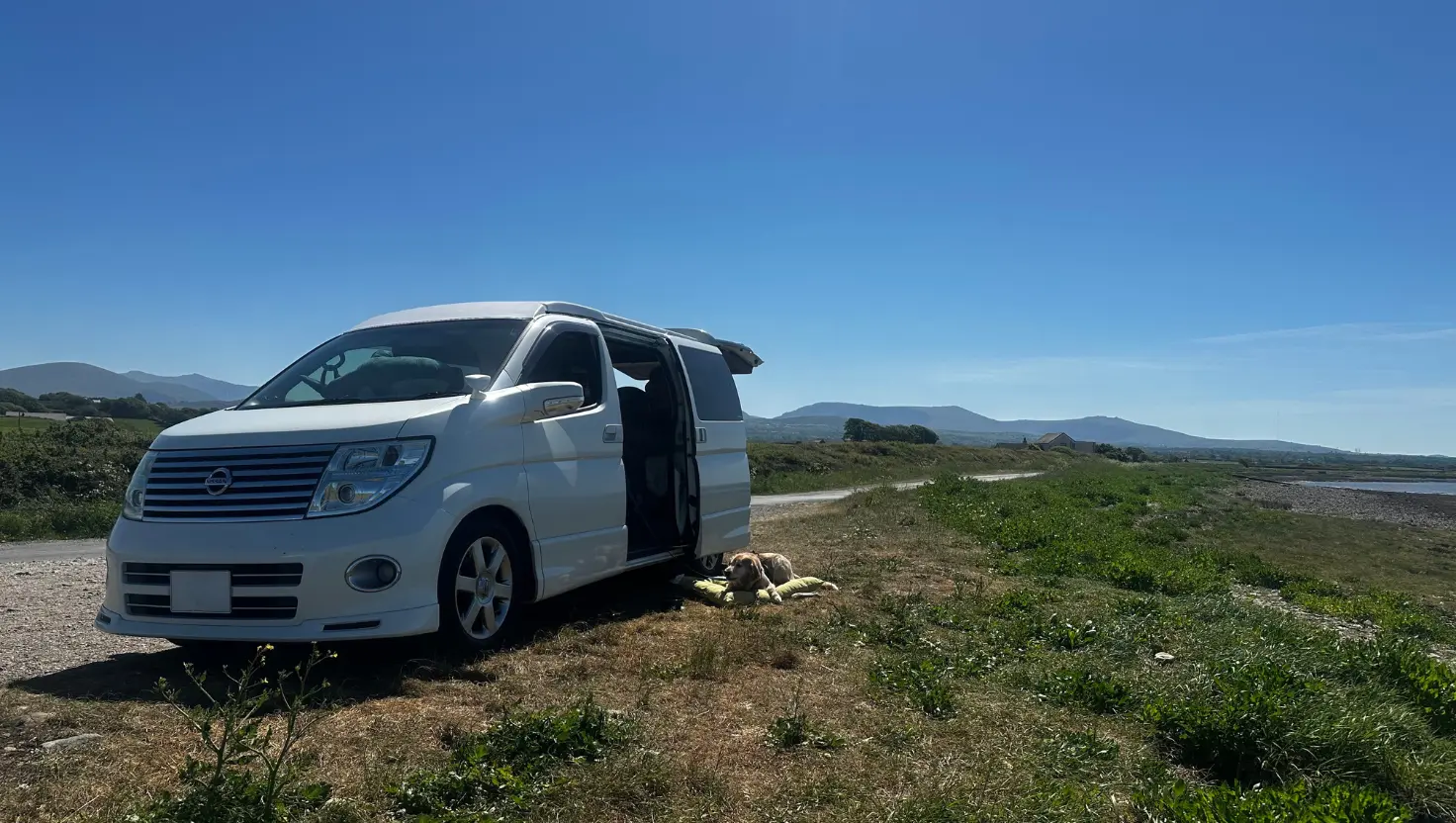 campervan parked by the coast with dogs for a a Campervan Wellbeing Retreat
