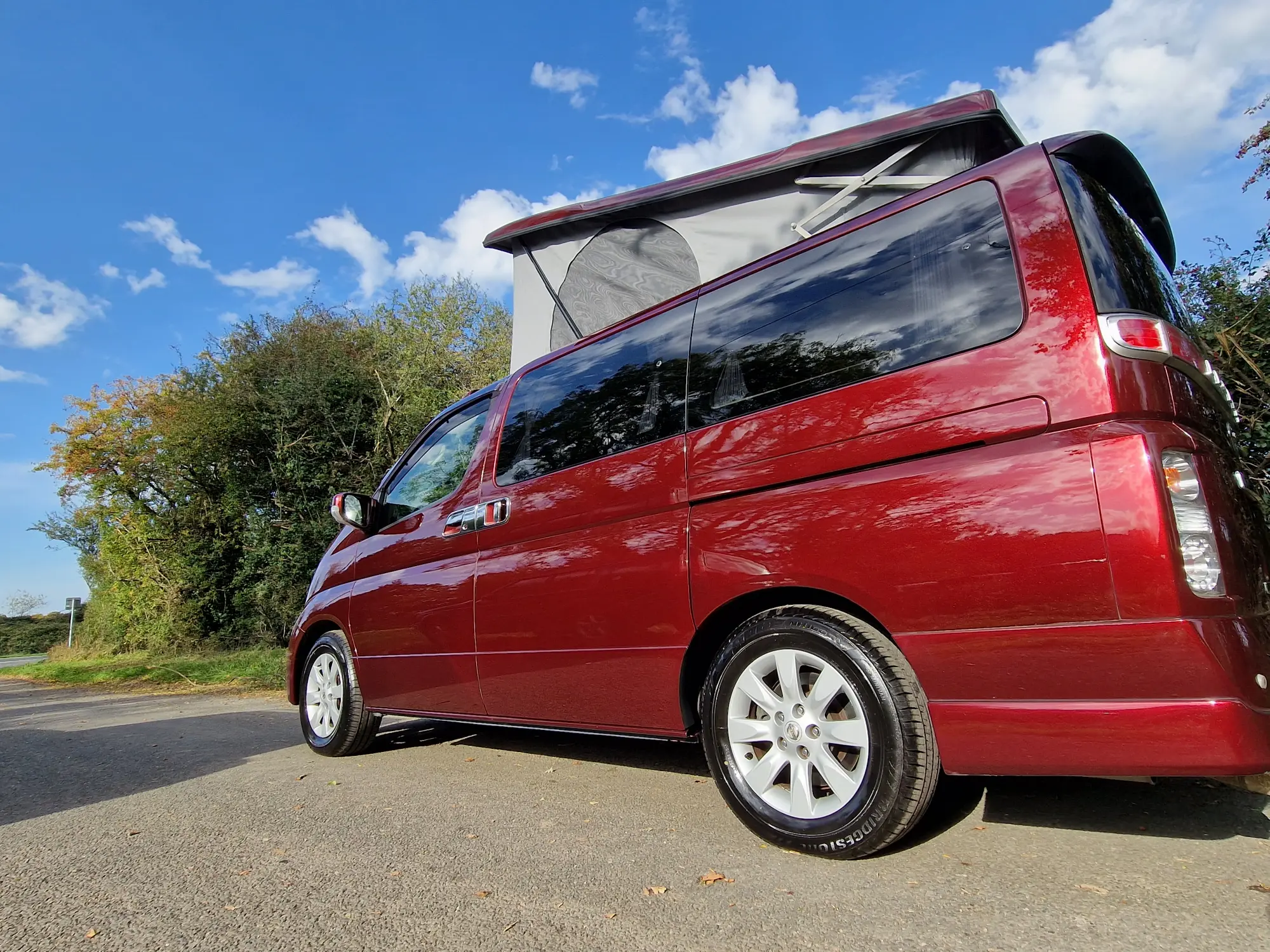 side view of a red Nissan elgrand Free Spirit campervan